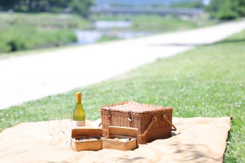 a picnic with a bottle of wine and glasses on a blanket at NOHGA HOTEL KIYOMIZU KYOTO in Kyoto