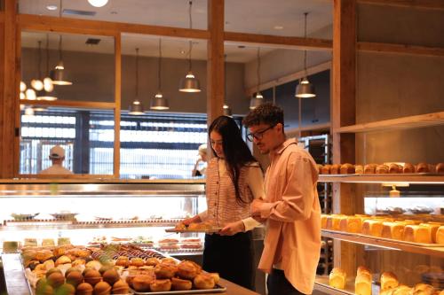 a man and woman preparing food in a bakery at NOHGA HOTEL KIYOMIZU KYOTO in Kyoto