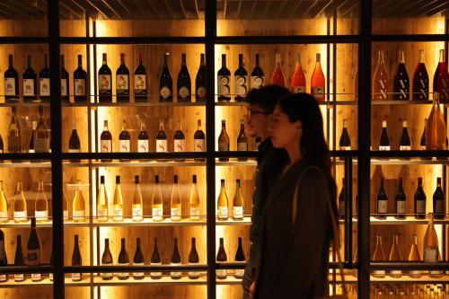 a couple standing in front of a display of wine bottles at NOHGA HOTEL KIYOMIZU KYOTO in Kyoto