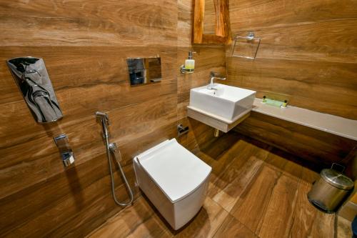 a bathroom with a white toilet and a sink at GoGo Land Resort & Adventurous Sports in Pūvār