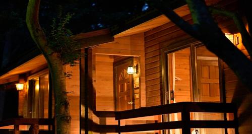 a wooden cabin with a door at night at Resol no Mori in Nagara