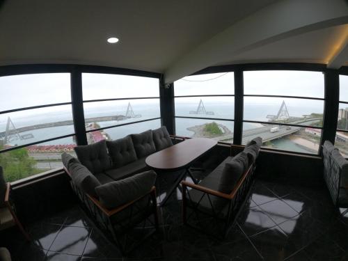 een kamer met stoelen en een tafel en zeilboten in het water bij Arhavi Resort Otel in Arhavi