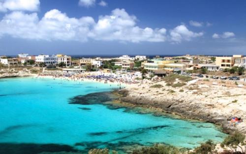 une plage avec un groupe de personnes dans l'eau dans l'établissement Mir Mar, à Lampedusa