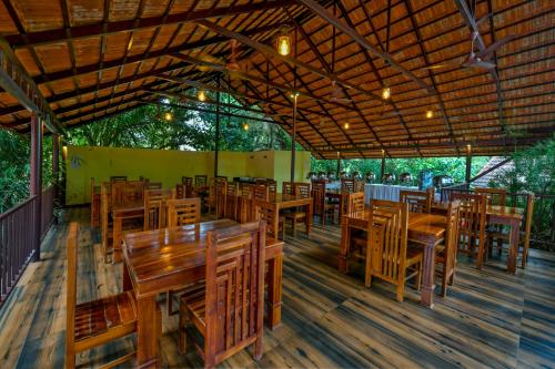 an empty restaurant with wooden tables and chairs at GoGo Land Resort & Adventurous Sports in Pūvār