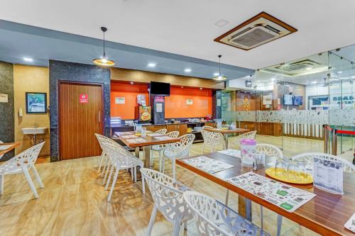 un restaurante con mesas y sillas y una cocina en Season 4 Residences - Nungambakkam Near US consulate, Apollo Hospital, Shankar Nethralaya en Chennai