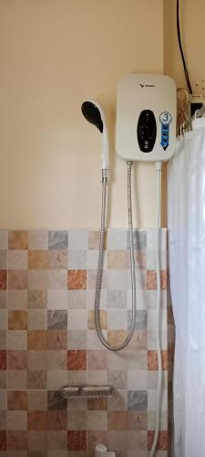 a shower in a bathroom with a blow dryer at Jessa's 5 Guests house in Moalboal