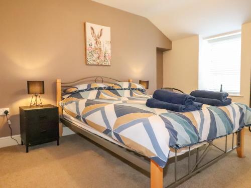 ein Schlafzimmer mit einem großen Bett und einem Fenster in der Unterkunft Rowarth in Pwllheli