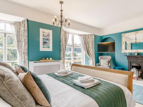 a blue bedroom with a bed and a fireplace at 4 Bed in Brixham 77366 in Brixham