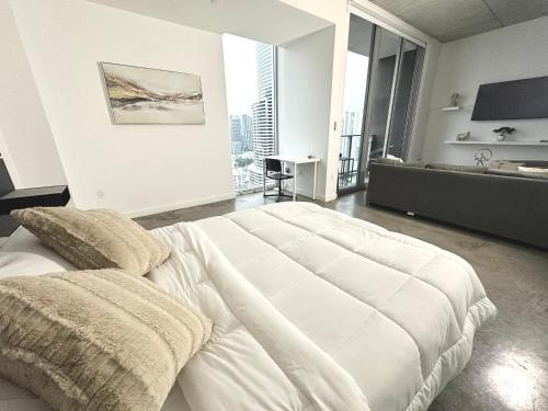 Pool Rooftop Luxury loft Miami Downtown, Brickell في ميامي: غرفة نوم مع سرير أبيض كبير في غرفة