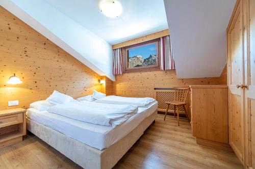 een slaapkamer met een groot bed en een raam bij Week End Senoner in Selva di Val Gardena