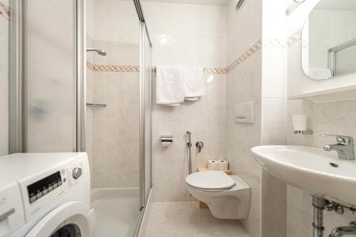 a bathroom with a shower toilet and a sink at Week End Senoner in Selva di Val Gardena