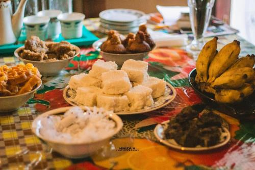 a table with plates of food on a table at Muru's Place in Dickwella