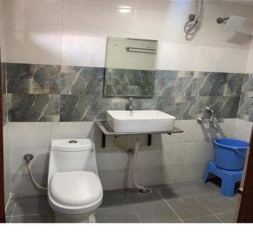 a bathroom with a white toilet and a sink at Supraja Cyber View in Hyderabad