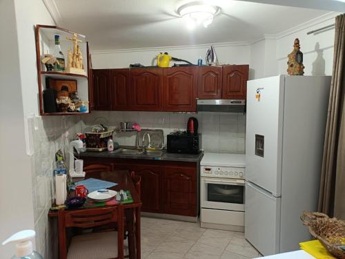 - une cuisine avec des placards en bois et un réfrigérateur blanc dans l'établissement Κουκλόσπιτο, à Thessalonique