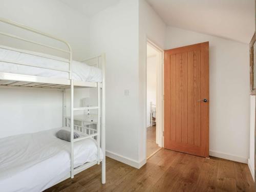 1 dormitorio con 2 literas y puerta de madera en 3 Bed in Newport 90245 en Newport