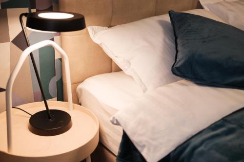 a black lamp on a table next to a bed at Konstanzer 44 - 1 camera, bucaterie, aer conditionat, masina de spalat in Iaşi