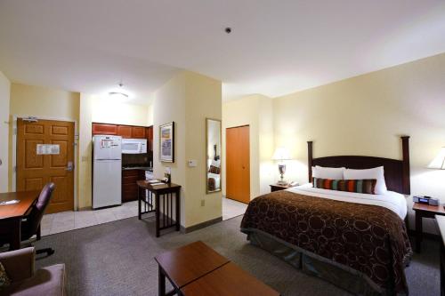 a hotel room with a bed and a kitchen at Staybridge Suites Corpus Christi by IHG in Corpus Christi