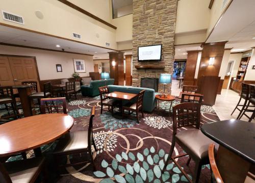 a hotel lobby with tables and chairs and a fireplace at Staybridge Suites Corpus Christi, an IHG Hotel in Corpus Christi