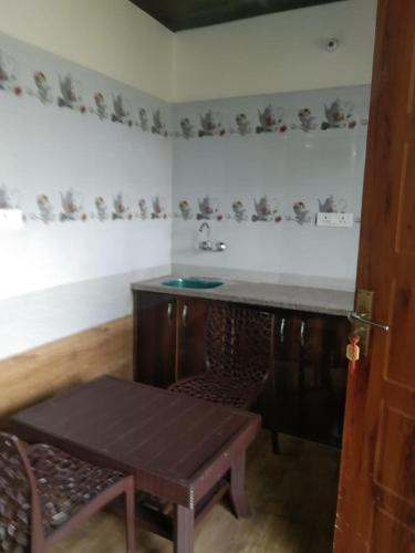 a kitchen with a table and a sink and a table at Badrinath B V by prithvi yatra hotels in Badrīnāth