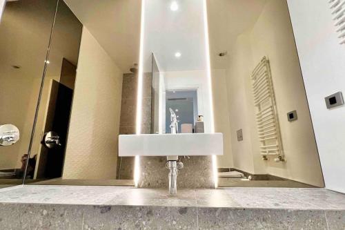 a bathroom with a sink in front of a mirror at Nordic Oasis Luxury 1 bedroom Aviatiei Tower in Bucharest