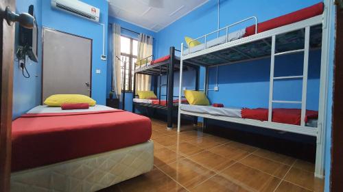 two bunk beds in a room with blue walls at ShopLot Hostel Pangkor in Pasir Bogak