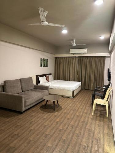 a living room with a bed and a couch at Weekend Address in Surat