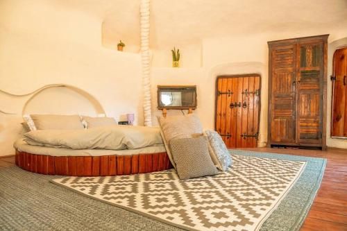 una camera con un letto con un tappeto e una TV di Unique Mud Home With Scenic Mountain Views a Nainital