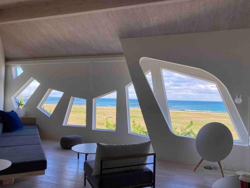 a living room with large windows and the ocean at wanderlust,SHIMA in Shima