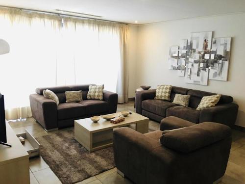 a living room with two couches and a coffee table at Incredible one bedroom space at East Legon in Accra