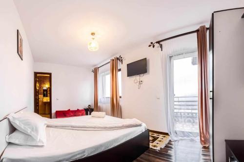 a bedroom with two beds and a window at Agropensiunea DarDen in Baia de Fier