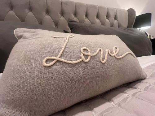 a pillow with the word au on it on a bed at Marmalade Barn Guest Suite with wet room in Rugeley