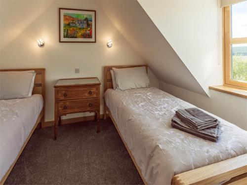 um quarto com 2 camas e uma janela em 4 Bed in Grantown on Spey CA027 em Grantown-on-Spey
