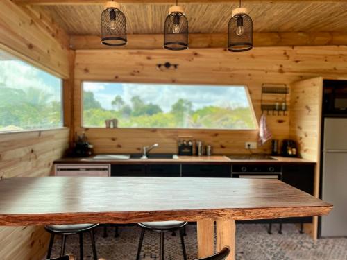 a kitchen with a wooden table and a large window at Ô Naturel Lodge Lifou in Lifou