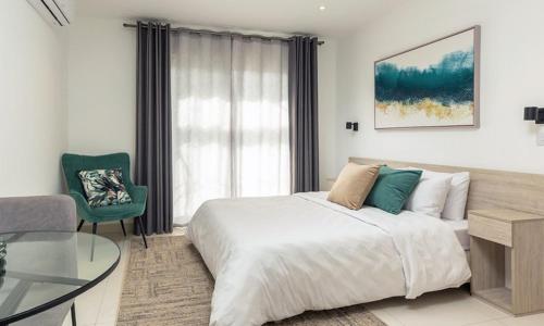 Luxurious loft space Available في آكرا: غرفة نوم بسرير كبير وطاولة زجاجية