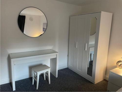 a bathroom with a vanity and a mirror and a stool at Woolwich 2Bedroom Apartment in London