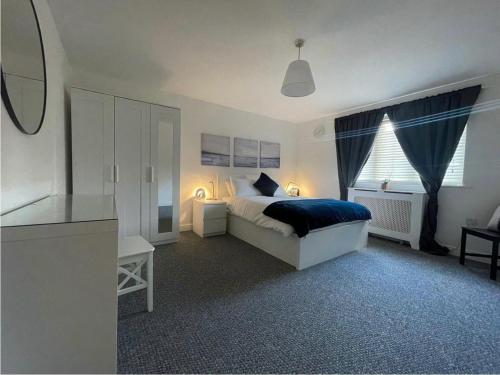 a white bedroom with a bed and a window at Woolwich 2Bedroom Apartment in London