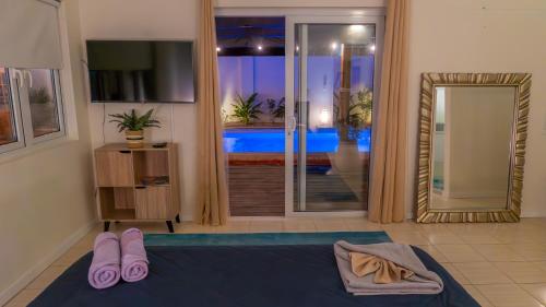 a bedroom with a bed and a sliding glass door at Sunny Eagle Beach Villa - 3 min. from beach in Palm-Eagle Beach