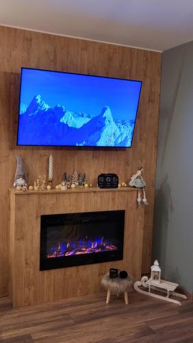 a living room with a flat screen tv above a fireplace at Pinewood ANG premium luxurious apartment 15 in Borovets