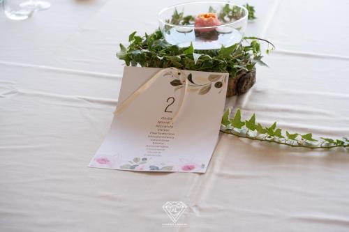 a table with a table sign with a flower arrangement at La Rondanina in Castelnuovo Fogliani