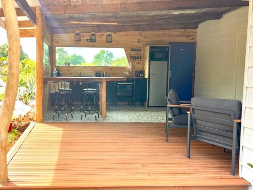 an open deck with a kitchen and a table at Ô Naturel Lodge Lifou in Lifou