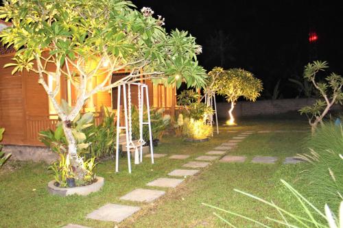 a garden at night with trees and a pathway at Green Village Jungle Resort in Nusa Penida