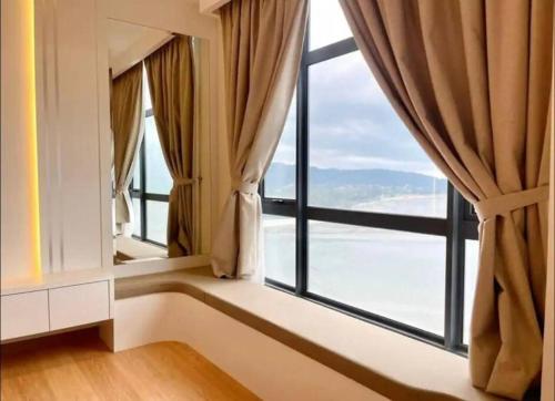 a room with a large window with curtains at 1 min to Seaview & Sunrise Heart of Kuantan in Kuantan