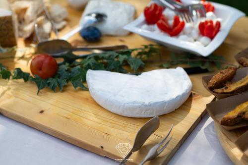 a cutting board with a piece of cheese and vegetables at La Rondanina in Castelnuovo Fogliani