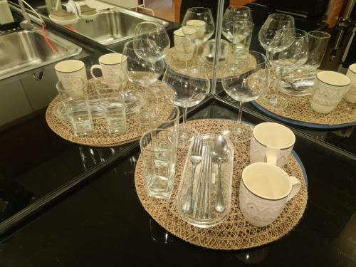 a group of glasses on a table with plates and utensils at KL Q520 Premium Suite Room in Kuala Lumpur