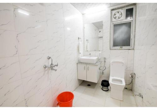 a white bathroom with a sink and a toilet at Amit House in Greater Noida