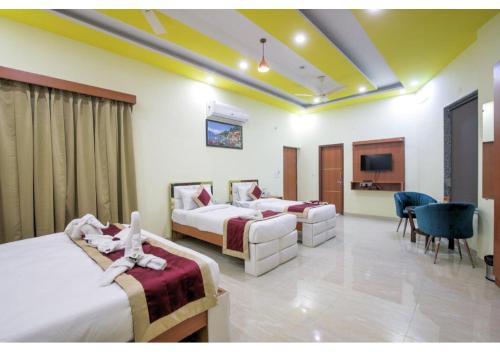 a hotel room with two beds and a television at Amit House in Greater Noida