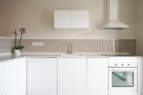 a white kitchen with white cabinets and a sink at Studio 10 / Tenerife in Chayofa