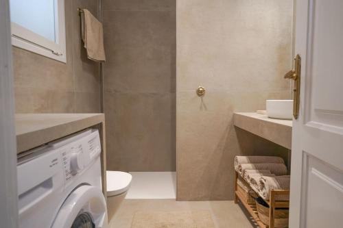 a bathroom with a toilet and a washing machine at Studio 10 / Tenerife in Chayofa