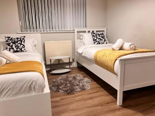 um quarto com 2 camas e uma janela em Exquisite 2 bedroom, Sleeps 4, Wifi LONG STAY WORK LEISURE CONTRACTOR - Lolite Apartment em Cambridge