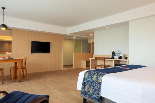 a hotel room with a bed and a dining room at Aveta Hotel Malioboro in Yogyakarta